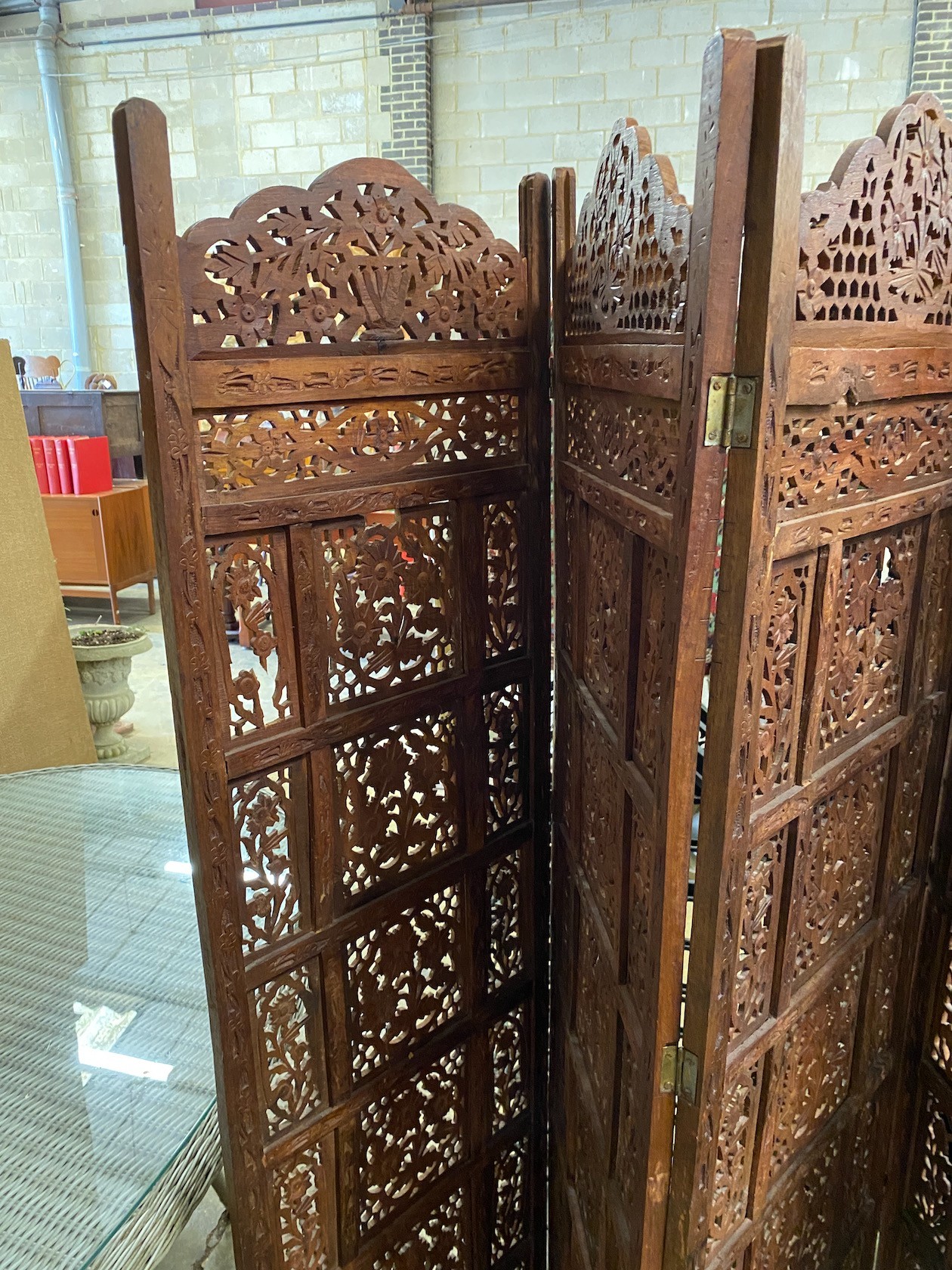 An Indian carved hardwood four fold screen, each panel width 51cm, height 183cm